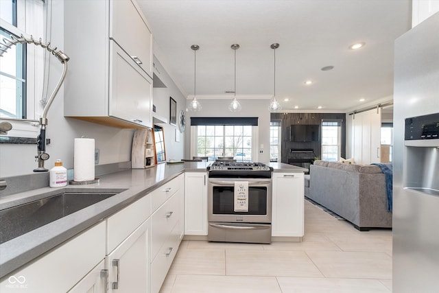 kitchen with ornamental molding, open floor plan, stainless steel appliances, a peninsula, and white cabinets