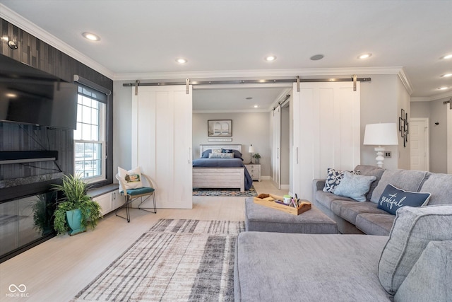 living area featuring recessed lighting, a barn door, a fireplace, and crown molding