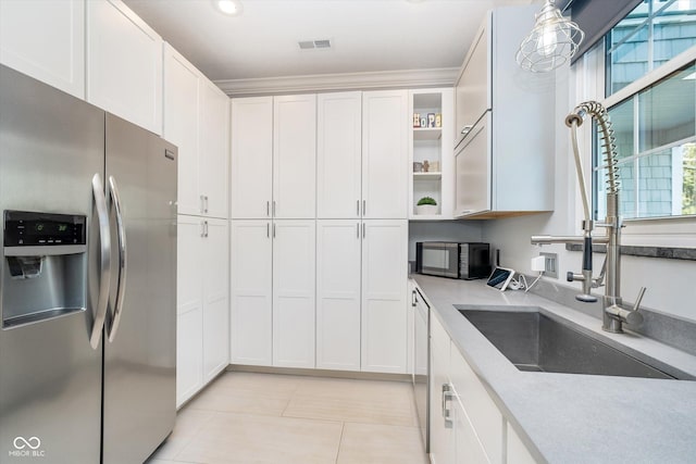 kitchen with black microwave, visible vents, stainless steel refrigerator with ice dispenser, and white cabinetry