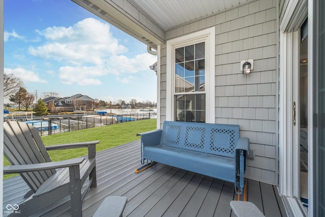 wooden deck with a yard and a water view