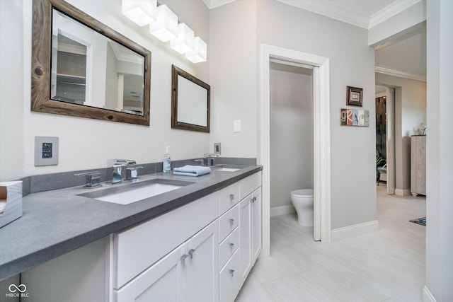 bathroom featuring double vanity, toilet, crown molding, and a sink