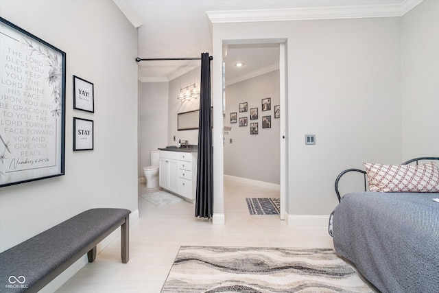 bedroom featuring ensuite bathroom, crown molding, and baseboards