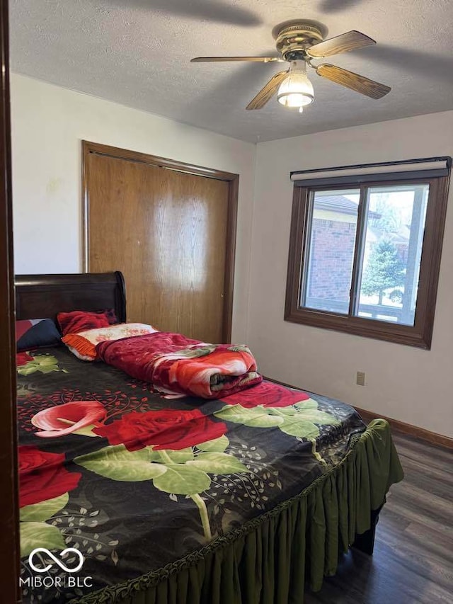 bedroom with a ceiling fan, baseboards, wood finished floors, a closet, and a textured ceiling