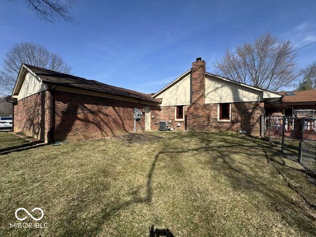 rear view of house featuring central air condition unit, fence, brick siding, and a chimney