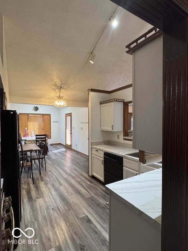 kitchen with black appliances, dark wood-type flooring, light countertops, an inviting chandelier, and a textured ceiling