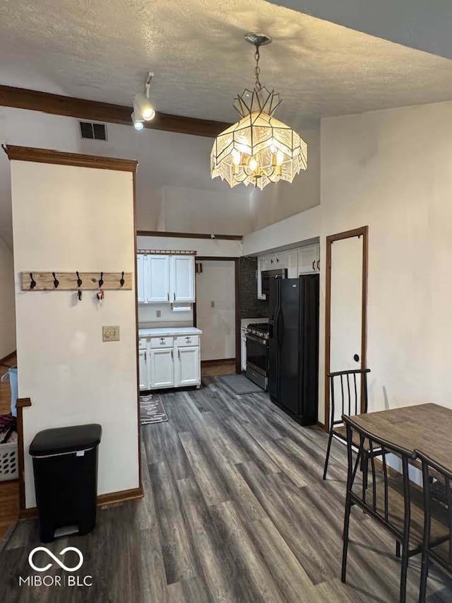 kitchen with visible vents, dark wood finished floors, freestanding refrigerator, gas range oven, and white cabinetry