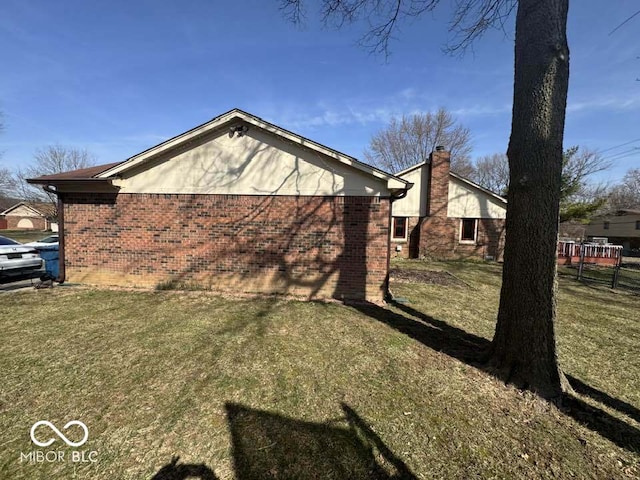 view of property exterior featuring a lawn and brick siding