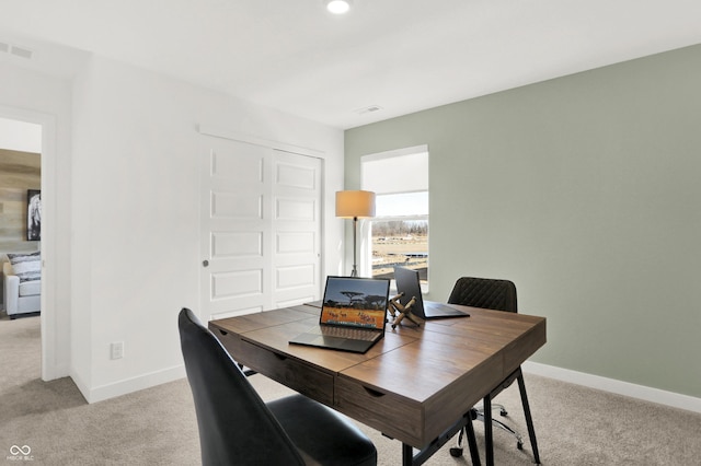 office area featuring light carpet, visible vents, and baseboards