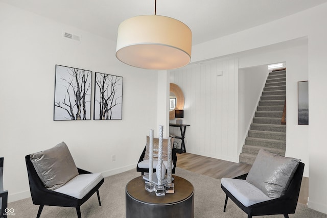 sitting room featuring visible vents, baseboards, and stairway