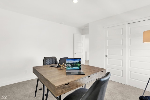 office with baseboards and light colored carpet