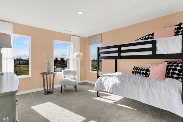 carpeted bedroom featuring visible vents, multiple windows, and baseboards