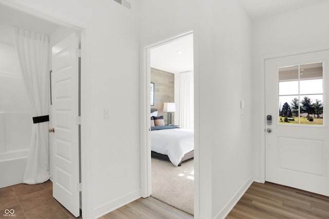 hallway featuring baseboards and wood finished floors