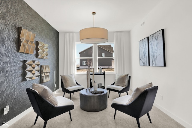 sitting room featuring visible vents, wallpapered walls, an accent wall, baseboards, and carpet floors