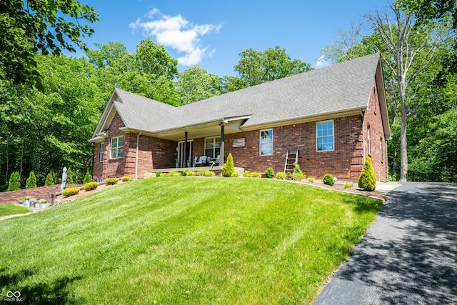 128 Walts Rd, Georgetown, IN 47122 - view of front of house with brick siding, a front yard, roof with shingles, asphalt driveway, and covered porch