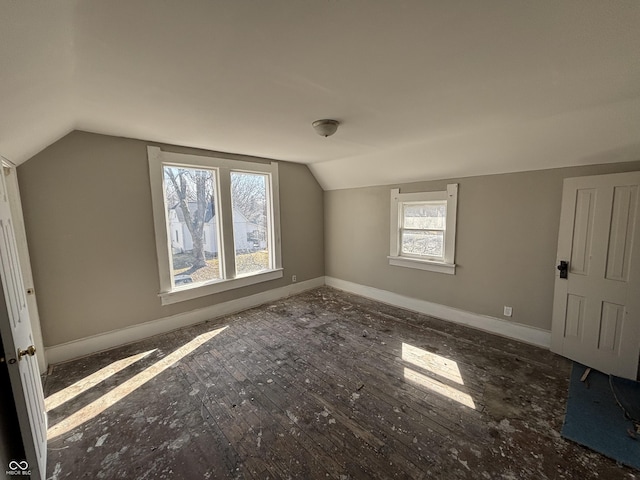 additional living space featuring baseboards, lofted ceiling, and wood-type flooring