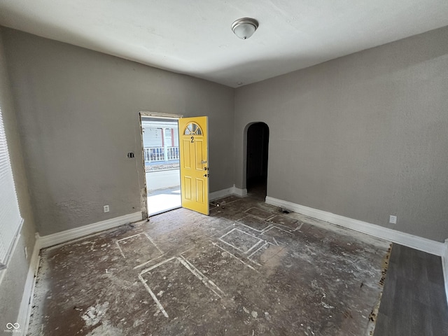 spare room with arched walkways and baseboards