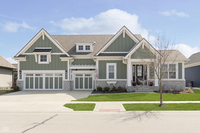 craftsman house with stone siding, board and batten siding, and concrete driveway