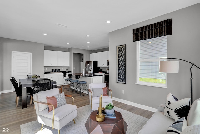 living area with visible vents, recessed lighting, baseboards, and light wood finished floors