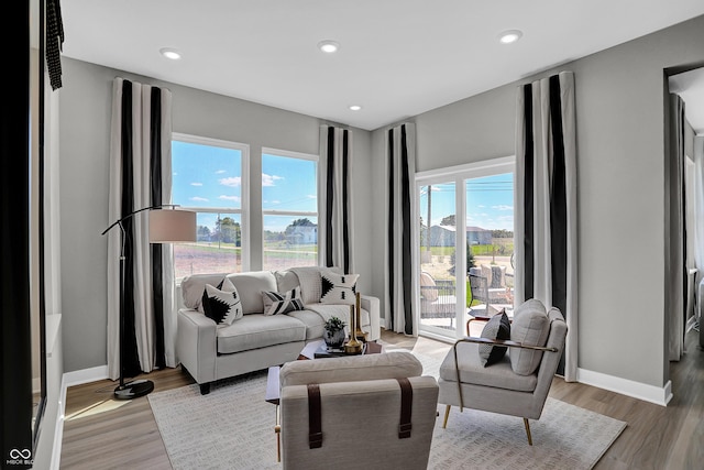 living room featuring recessed lighting, baseboards, and light wood-style floors