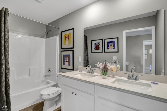 full bathroom featuring toilet, wood finished floors, shower / bath combo with shower curtain, and a sink