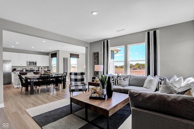 living room with recessed lighting, visible vents, and light wood-style floors