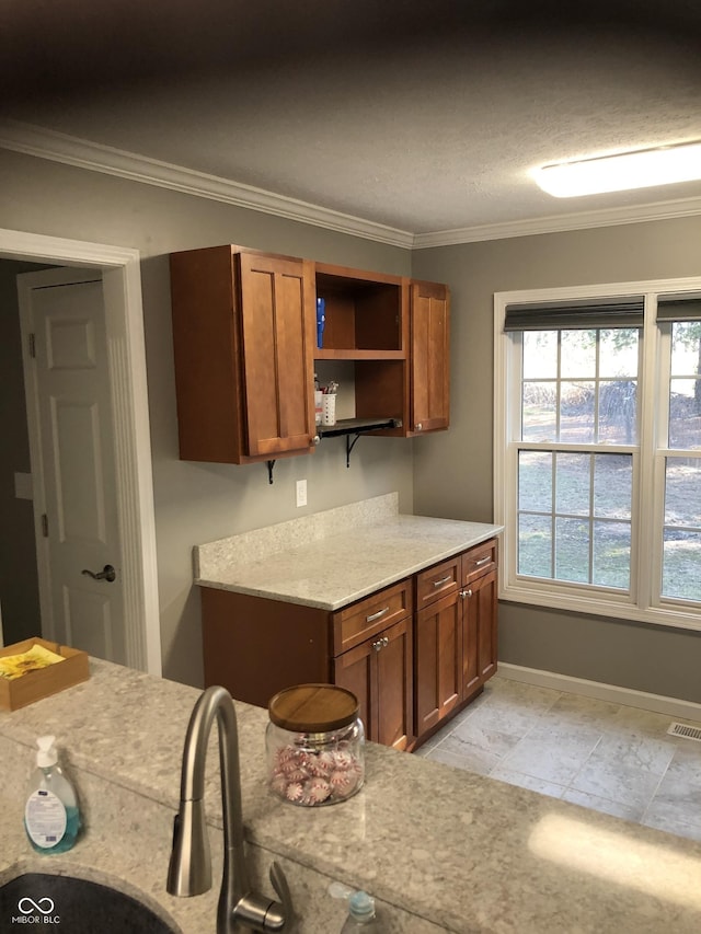 kitchen featuring visible vents, ornamental molding, open shelves, brown cabinetry, and baseboards