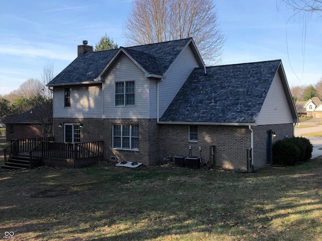 rear view of house featuring brick siding, a chimney, and a yard