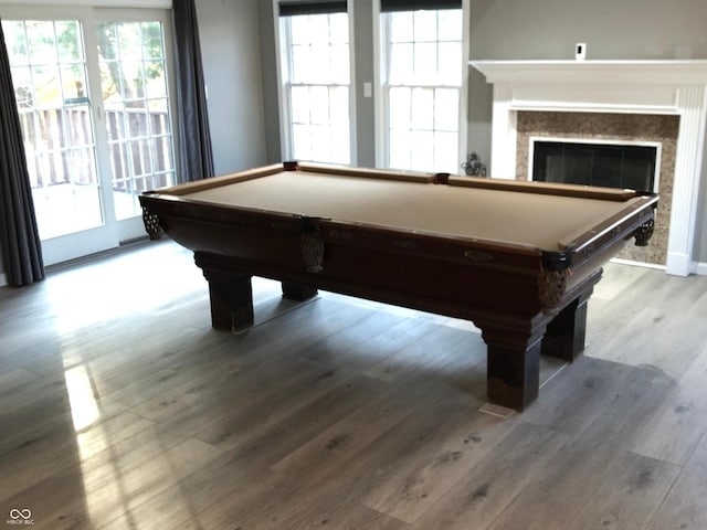 playroom featuring a wealth of natural light, a glass covered fireplace, wood finished floors, and billiards