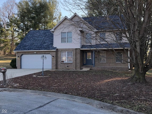 traditional-style house featuring concrete driveway, an attached garage, and brick siding