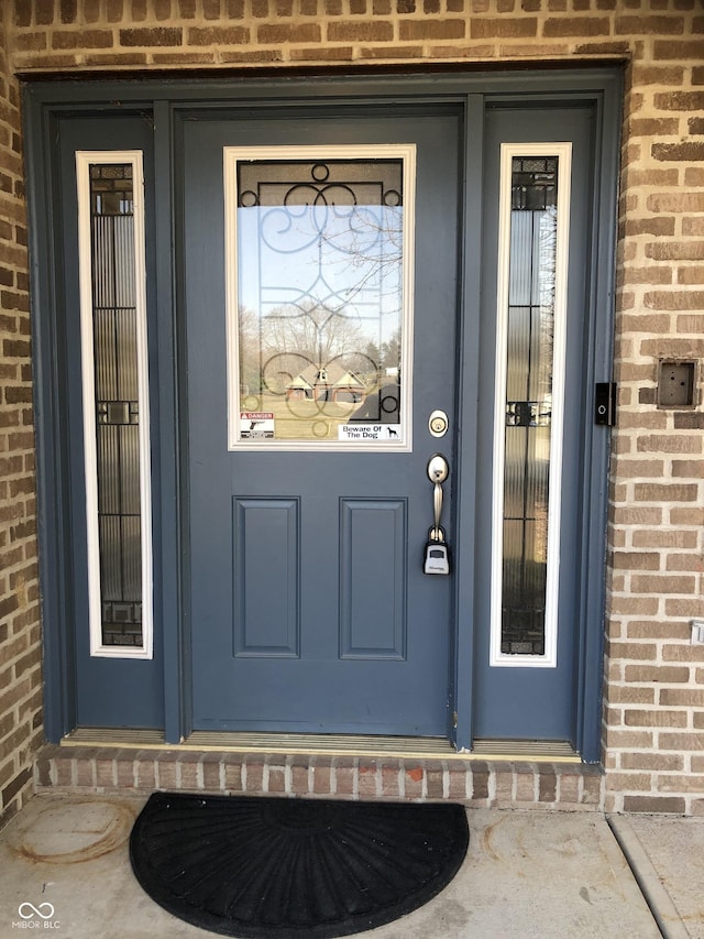 property entrance featuring brick siding