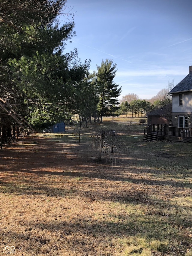 view of yard featuring a rural view and a wooden deck