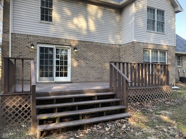 back of property with brick siding and a deck