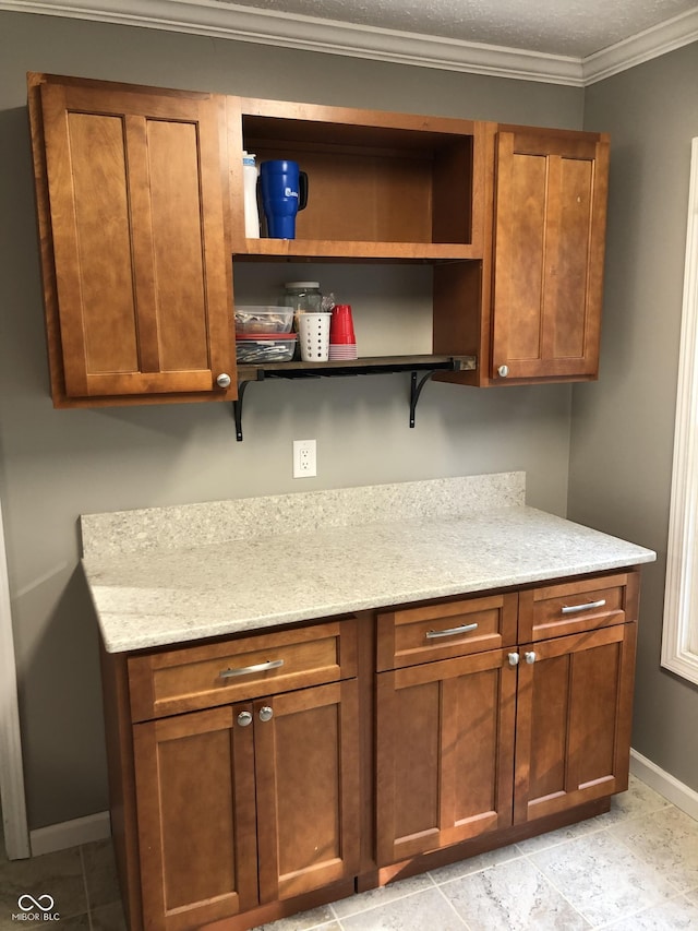 interior space with light stone counters, baseboards, open shelves, ornamental molding, and brown cabinets