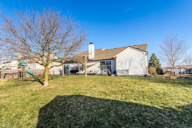 back of property with a playground, a lawn, a chimney, a fenced backyard, and a patio