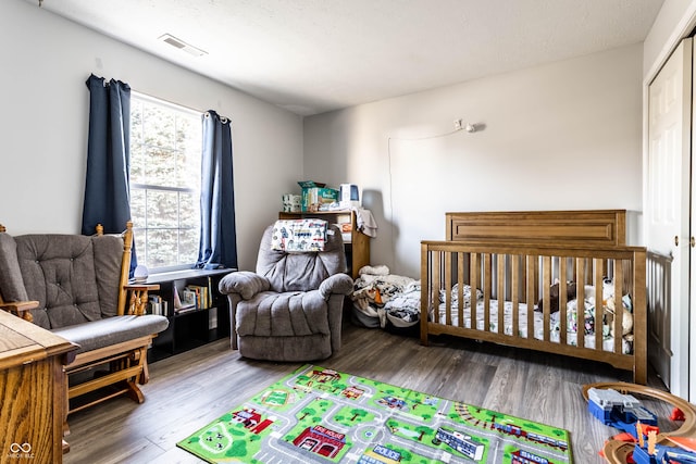 bedroom featuring wood finished floors and visible vents