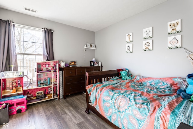 bedroom featuring visible vents and wood finished floors