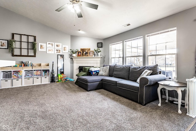 living area featuring visible vents, radiator, ceiling fan, carpet flooring, and a fireplace