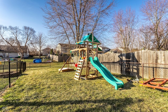 view of playground with a lawn and fence