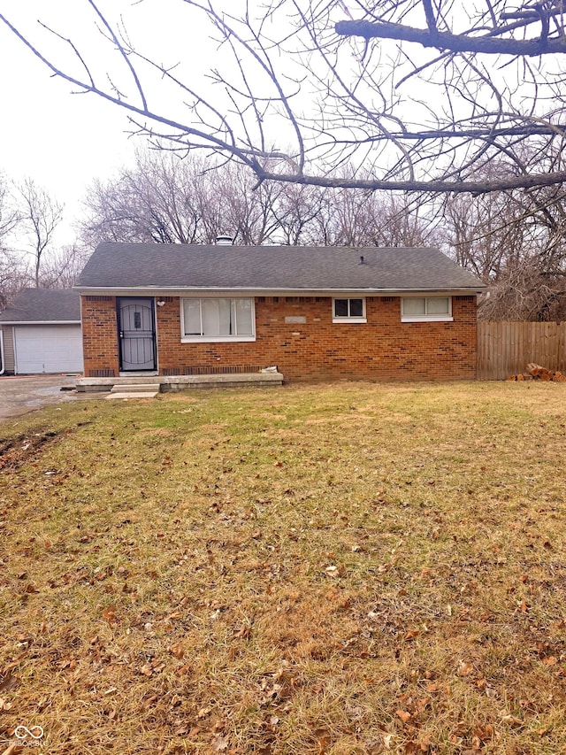 ranch-style house with a front lawn, fence, and brick siding