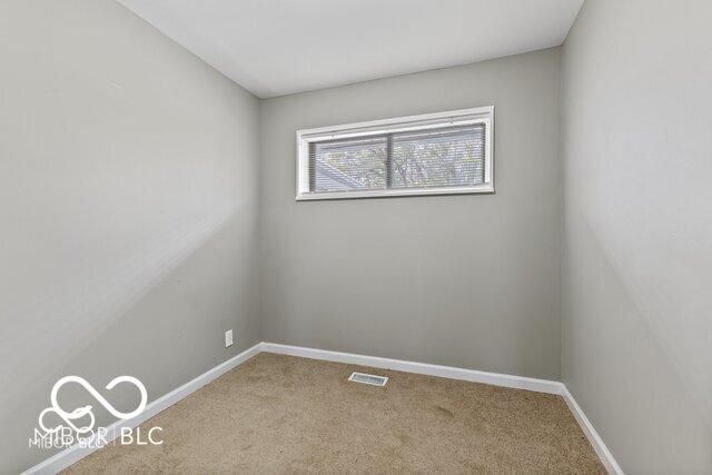 spare room featuring visible vents, carpet floors, and baseboards