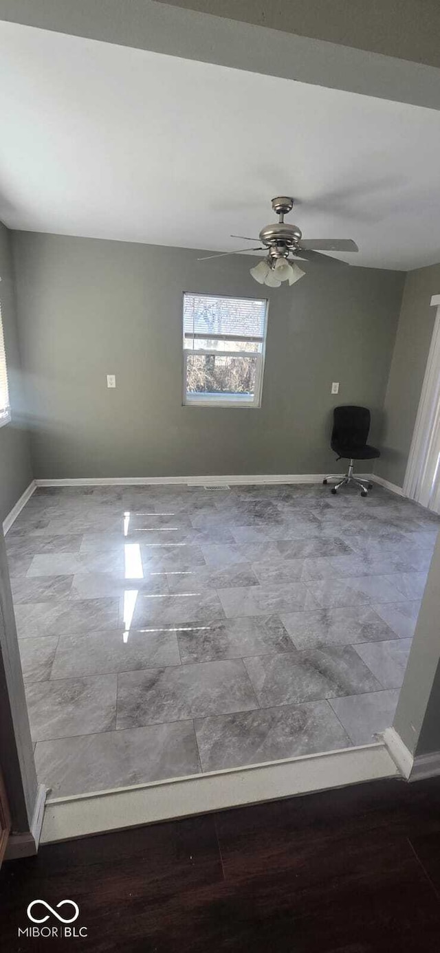 empty room with baseboards and ceiling fan