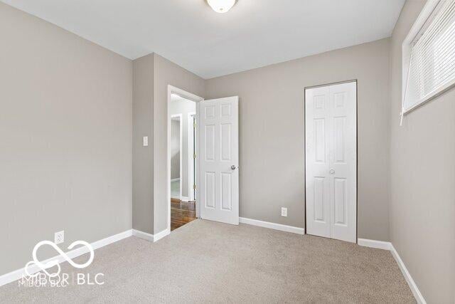 unfurnished bedroom featuring a closet, carpet, and baseboards