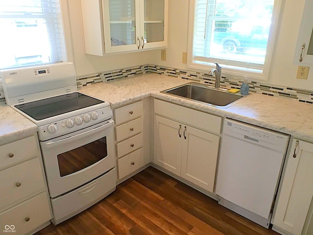 kitchen with dark wood finished floors, white appliances, a wealth of natural light, and a sink