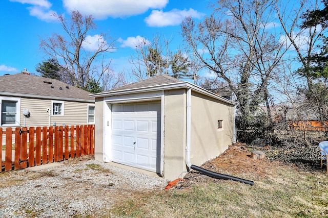 detached garage featuring fence