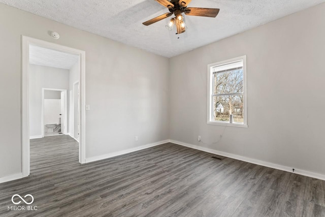 unfurnished room featuring baseboards, a textured ceiling, dark wood-type flooring, and ceiling fan