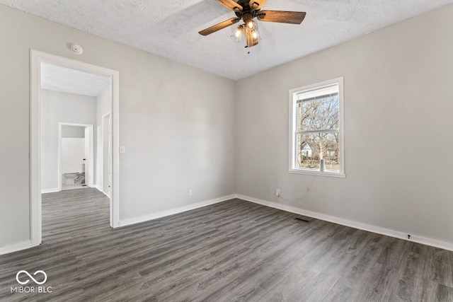 empty room with a textured ceiling, ceiling fan, and dark wood-style flooring