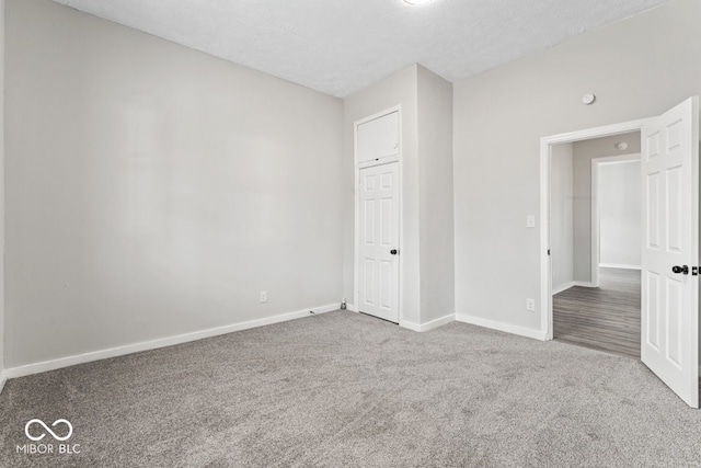 unfurnished bedroom with baseboards, a textured ceiling, and carpet flooring