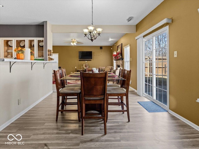 dining room featuring an inviting chandelier, baseboards, and wood finished floors