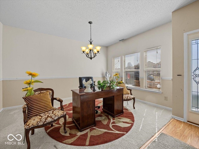 carpeted home office with baseboards, a textured ceiling, and a chandelier