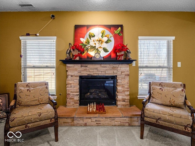 living room with visible vents, plenty of natural light, carpet floors, and a fireplace